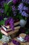 Still life books, coffee and lilacs in the dark key.Spring background