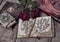 Still life with botanical drawings on shappy pages, decorated book and roses on planks