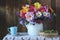 Still life with a bouquet of flowers in a teapot, green gooseberries