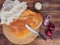 Still life with bread on the background of the old wood. Scattered on the table salt, purple onion. Composition in a