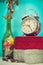 Still life with broken alarm clock, metal cross with metal necklace, old glass vase with dead rose, vintage boxs, tone image.