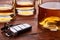 Still life with car keys and glass or bottles of whiskey. Wooden table top