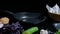 Still life of chef`s table on black surface. Pan, knife, fresh vegetables and ingredientes for dish