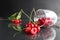 Still life cherry berries fell out of the glass on a black background. Season berries vitamins side view red berries