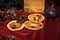 Still life of coffee beans, dried orange and figs on a red background. Along the edge there are Christmas tree decorations and a