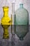 Still life with colored bottles on a reflective surface
