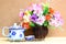 Still life with colourful bunch in wood vase and tea pot on wooden table