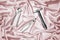Still life of construction tools hammer, pliers, tongs on pink satin fabric
