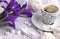 Still life with cup of coffe marshmallow zephyr iris flowers heart sign on white wooden background.