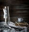 Still-life with a cup of coffee, scissors, mannequin sewing and lace on a background of rough wooden walls. vintage