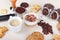 Still life with cup of espresso, cappuccino with chocolate crumbs, cookies, crackers, holder with ground coffee, tamper and coffee