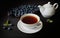 Still life, cup with tea, teapot, blueberry and dry leaves of mellisa