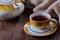 Still life with cup of tea and teapot on old wooden table