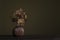 Still life with a deep red vase and blooming orchids on a olive green still life background