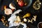 Still life on dinner table with cheese pieces, pear, white wine, walnut, pomelo on wooden board