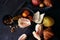 Still life on dinner table on grey background with cheese pieces, pear, walnut, pomelo on wooden board. Pomegranate fruit.