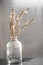 Still-life. Dry reeds in a glass vase on the background of a wet window