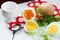 Still life with eggs, dill, spoon and red napkin in white table.