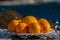 Still life eight oranges on white plate with water drops spraying