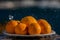 Still life eight oranges on white plate with water drops spraying, selective focus on the front row