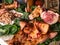 Still life of the exploded view of a pig with a large pig mask and leftover meat on cabbage leaves