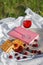 Still life and food photo. Cherry and waffle berries lie on a wicker round napkin and crumpled fabric