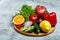 Still life of fresh organic vegetables on wooden plate over white background, selective focus, close-up