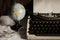 Still life globe and eyeglasses with typewriter.