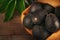 Still life of Hass avocados in a burlap sack on a wood background with leaves and warm side light