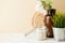 Still life with home decor candle, vase, green plant in a pot with space for text. Horizontal photo, life style concept