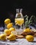 Still life with homemade lemonade. a bottle of lemonade with lemon slices on a table littered with lemons