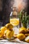 Still life with homemade lemonade. a bottle of lemonade with lemon slices on a table littered with lemons