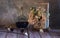 Still life with homemade liquor and a wooden basket with flowers close-up