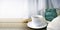 Still life hygge kitchen details on desktop. Coffee cup, blanket and light glass on wooden desk.