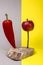 Still life with an iron nail, apple and red pepper