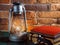 Still life kerosene lamp shines on wooden desktop stone brick background book camera.