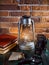 Still life kerosene lamp shines on wooden desktop stone brick background book camera.