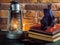 Still life kerosene lamp shines on wooden desktop stone brick background book camera.