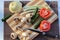 Still life - a knife, mushrooms and vegetable tomato, zucchini, pattypan and leek on a cutting board