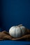 Still life of light pumpkin lies on a rough brown bag for vegetables on a blue background side view