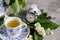 Still life with a magnificent tea set with jasmine flowers and a clock bulb.