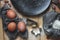 Still life making homemade cookies for Christmas with cookies, black plate, flour, egg, nuts, chocolate, grater, stick spoon,