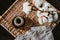 Still life of objects like wooden plate, cotton branch, linen towel and twine on a rattan box.