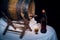 Still life with old oak wine barrel, bottle and wine glasses on black background