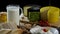 Still life in the old style with a jug and a mug of milk, a heads of cheese, toast, honey and eggs on black background