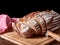 Still life on old wooden board table with sliced loaf of bread. Kitchen knife on black background