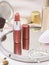 Still life. Opened lipstick on the morror surrounded by woman accessories and cosmetics. Vertical. Selective focus, Nude