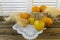 Still life with oranges, basket and glass jug with juice on old  wooden background