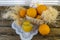 Still life with oranges, basket and glass jug with juice on old  wooden background