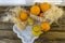 Still life with oranges, basket and glass jug with juice on old  wooden background